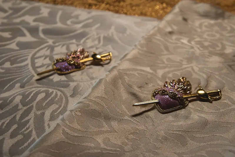 Side-by-side view of two Immaculate Heart embroidery pieces arranged on a rich gold brocade fabric.